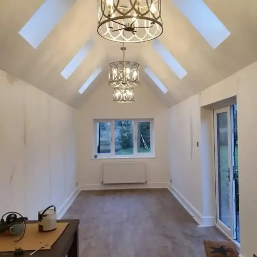 Garage conversion with a vaulted ceiling, roof lights and pendant lights, plastered and floored