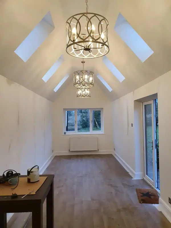 Double garage conversion finished as a vaulted living space with roof lights and oak-effect flooring